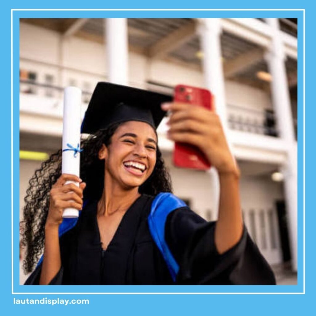 Lulusan berfoto selfie sambil memegang ijazah setelah wisuda